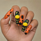 Halloween pumpkin spider coffin press on nails worn on a deep skin tone hand