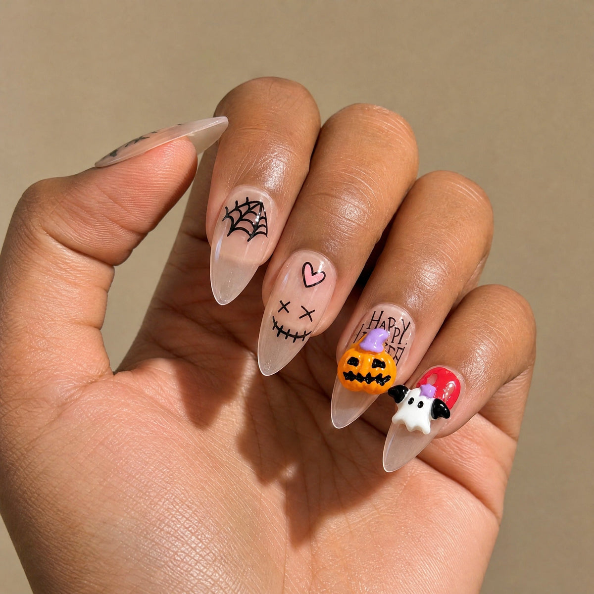 Halloween ghost pumpkin web stiletto press on nails worn on a deep skin tone hand
