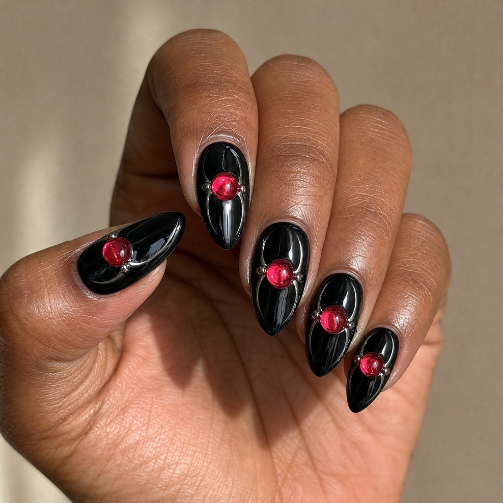 Black almond with red gem press on nails worn on a deep skin tone hand